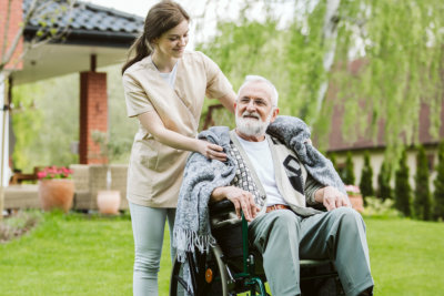 Senior with helpful caregiver in the garden