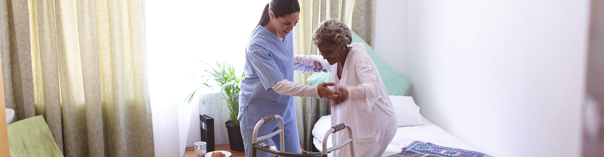 caretaker helps elder woman stand up